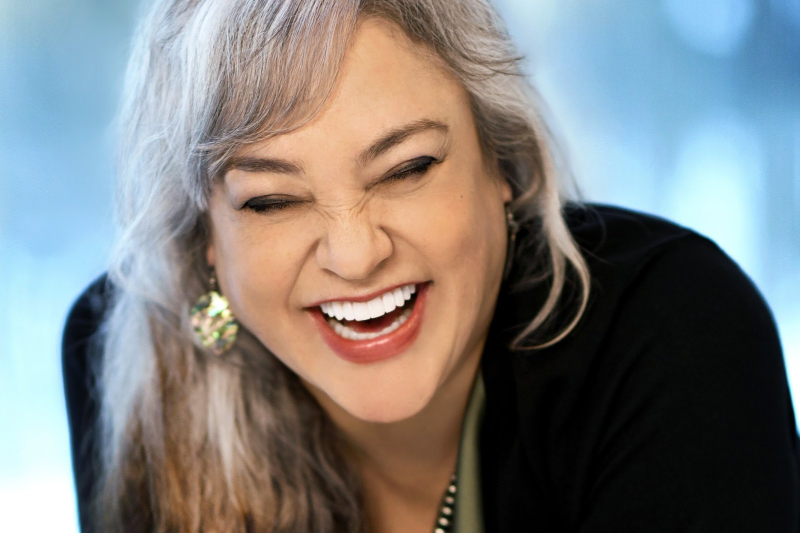 A woman laughing with a bright, natural smile